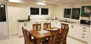 a kitchen with a wooden table and some chairs at Te Etu Villa 2 in Rarotonga