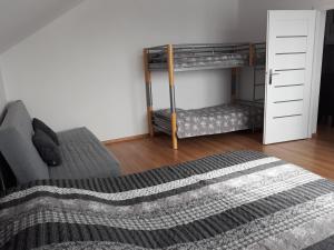 1 Schlafzimmer mit 2 Etagenbetten und 1 Bett in der Unterkunft Agroturystyka u Krzysztofa in Graboszyce