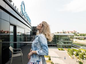 
a woman standing in front of a bus at Q Hotel Plus Kraków in Kraków
