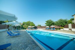 a swimming pool with blue lounge chairs and umbrellas at Hotel Alkionis in Moraitika