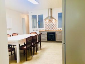 a kitchen with a white table and chairs at Villa Bigorra Lourdes centre Le Sanctuaire La Grotte , parking in Lourdes