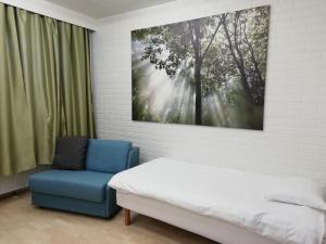 a bedroom with a bed and a blue chair at Hotel Turistihovi in Kouvola +27 photos