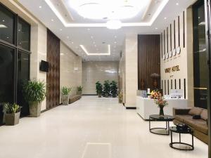 an office lobby with a couch and plants at Windy Hotel Quang Binh in Dong Hoi