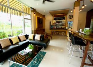 a living room with a black couch and a table at Breezotel - SHA Certified in Patong Beach