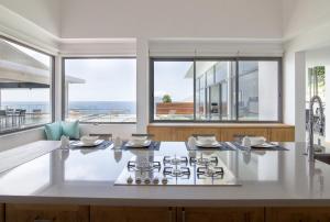 a kitchen with a stove and large windows at AquaBlu Villa in Victoria