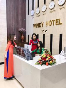 ドンホイにあるWindy Hotel Quang Binhのホテルのフロントカウンターに立つ女性2名