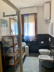 a bathroom with a sink and a toilet and a mirror at Casa Del Mar in Alghero