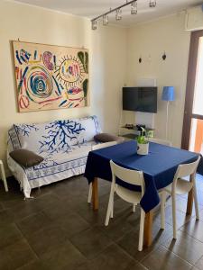 a living room with a blue table and a couch at Casa Del Mar in Alghero