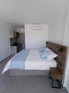 a bedroom with a large white bed with blue pillows at Shalos Studios in Ayia Napa