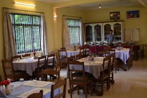 a dining room with tables and a man standing in the background at sakya guest house in Rummindei