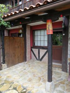 una casa con una puerta de madera y un poste con una bandera en Iturbe1 en Busturia
