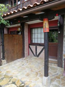 una casa con una puerta de madera y un poste con una bandera en Iturbe1, en Busturia 2 fotos más