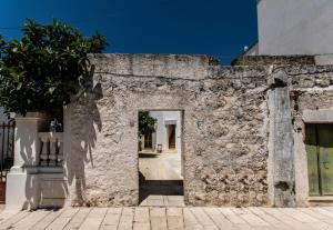 an alley in a stone wall with a doorway at Il Galletto bb in Patù