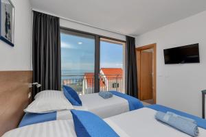 two beds in a room with a large window at Villa Smart in Veliko Brdo +38 photos