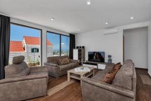 a living room with two couches and a tv at Villa Smart in Veliko Brdo