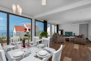 a dining room with a white table and white chairs at Villa Smart in Veliko Brdo