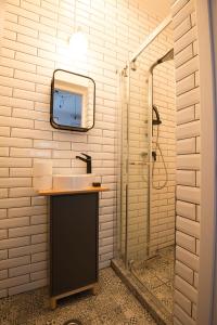 ein Bad mit einem Waschbecken und einem Wandspiegel in der Unterkunft George Enescu Suites in Bukarest