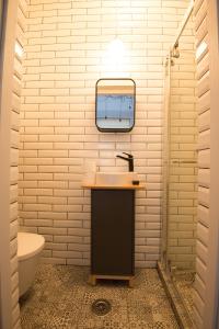 ein Bad mit einem Waschbecken und einem Wandspiegel in der Unterkunft George Enescu Suites in Bukarest