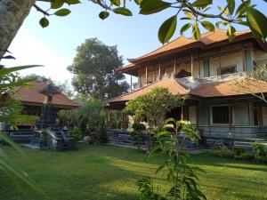a house with a grass yard in front of it at Taman Sari Tagtag in Sanur