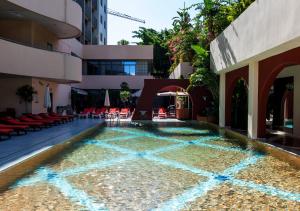 uma piscina no meio de um edifício em Lancaster Tamar Hotel- Hadath em Beirute