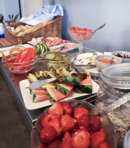 uma mesa coberta com pratos de frutas e produtos hortícolas em Hotell Apladalen i Värnamo em Värnamo