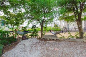 two people in hammocks in a park with trees at 曉翠軒親子民宿 in Wujie