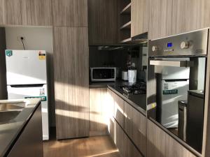 a kitchen with stainless steel appliances and wooden cabinets at Skyview Apartment in Liverpool in Liverpool