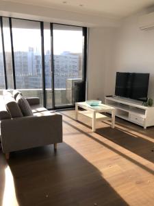 a living room with a couch and a tv at Skyview Apartment in Liverpool in Liverpool