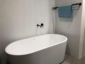 a white bath tub in a bathroom with a blue towel at Skyview Apartment in Liverpool in Liverpool