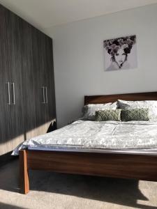 a bedroom with a bed with a wooden headboard at Skyview Apartment in Liverpool in Liverpool