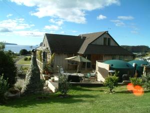 una casa con patio con mesa y sillas en Leighton Lodge Seahorse Suite, en Opito Bay