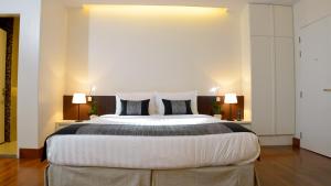 a bedroom with a large bed with two lamps at Residence26 in Yangon