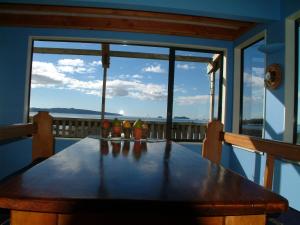 una mesa de madera en un balcón con vistas al océano en Leighton Lodge Seahorse Suite, en Opito Bay