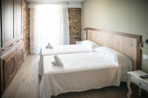 sypialnia z dwoma białymi łóżkami i oknem w obiekcie Hotel portico w mieście Fonsagrada +10 zdjęć