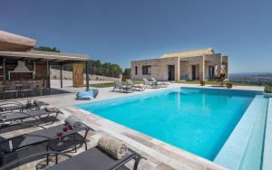 LithakiaにあるZinos Luxury Villaのスイミングプールとパティオ付きのヴィラ