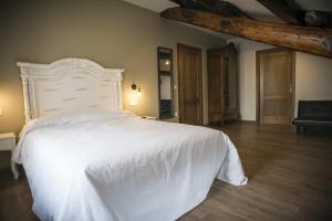 sypialnia z białym łóżkiem i krzesłem w obiekcie Hotel portico w mieście Fonsagrada