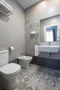 a bathroom with a toilet and a sink at Apartamentos Casa de la Lonja in Granada
