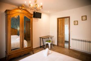 Hotel portico في فونساغرادا: غرفة نوم مع خزانة خشبية كبيرة وسرير