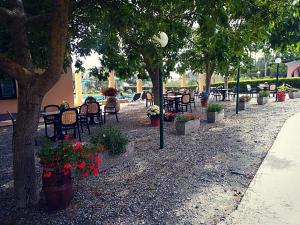 a park with tables and chairs and trees and flowers at La Rossola Resort & Natura in Bonassola