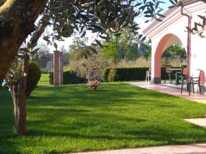 a yard with green grass and an arbor with a tree at La Rossola Resort & Natura in Bonassola