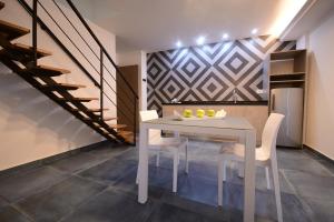 a dining room with a table and chairs and a staircase at Brazilia Suites Hotel in Baabda