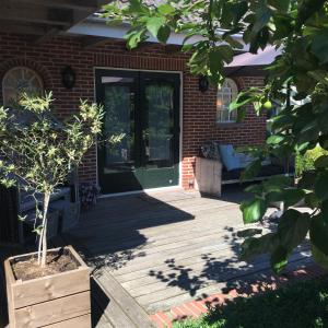 a front porch of a brick house with a green door at De Strandkorf in Roodeschool