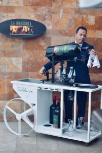 a man is standing next to a bar with wine bottles at Gran Hotel Guadalpín Banus in Marbella