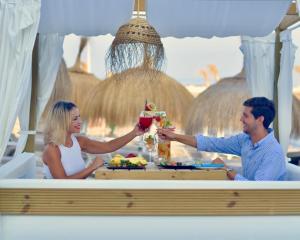 a man and woman sitting at a table with a drink at Gran Hotel Guadalpín Banus in Marbella +37 photos