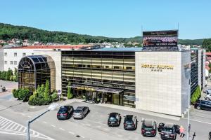 un estacionamiento con autos estacionados frente a un edificio en Hotel SPA Faltom Gdynia Rumia en Rumia