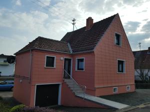 Una pequeña casa roja con una escalera. en Zimmervermietung St.Wendel en Sankt Wendel