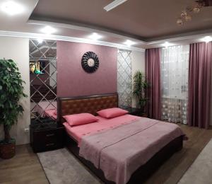 ein Schlafzimmer mit einem großen Bett mit rosa Bettwäsche in der Unterkunft Apartment in a New House in Krementschuk