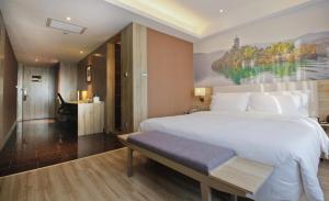 a bedroom with a large white bed and a desk at Atour Hotel Xi'an Gaoxin Tangyan Road Branch in Xi'an