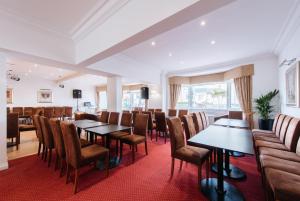 a restaurant with tables and chairs in a room at The Queens Hotel in Paignton