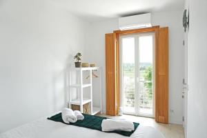 a bedroom with a bed and a large window at Mood Lodging - Caldas & Ocean in Óbidos